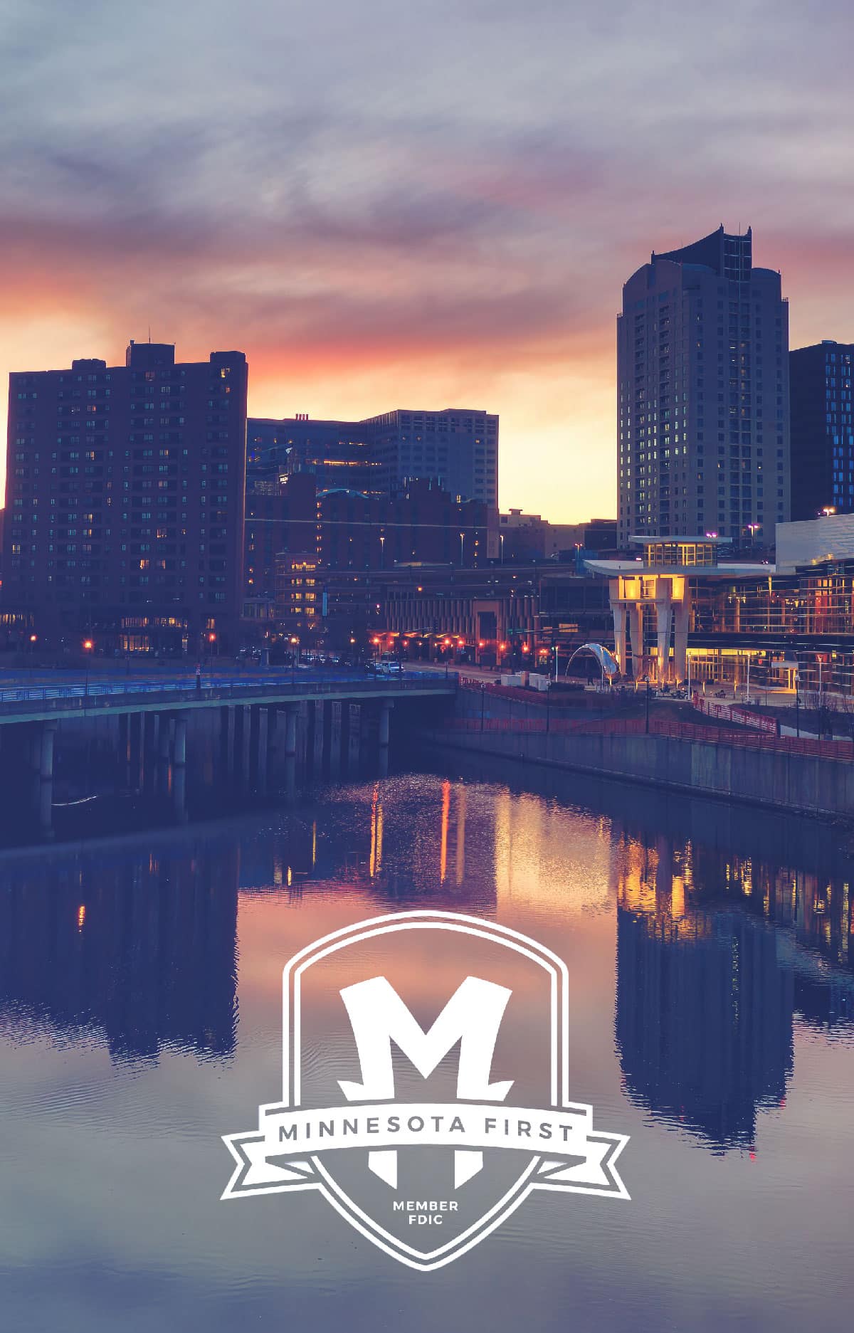 Rochester’s downtown skyline at sunset reflected in the river, with the Minnesota First logo overlay.